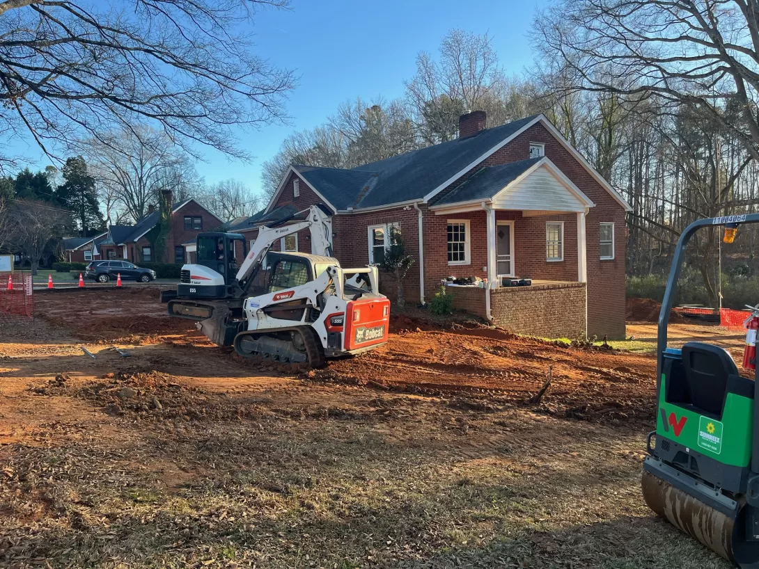 Work machines leveling the land for a driveway